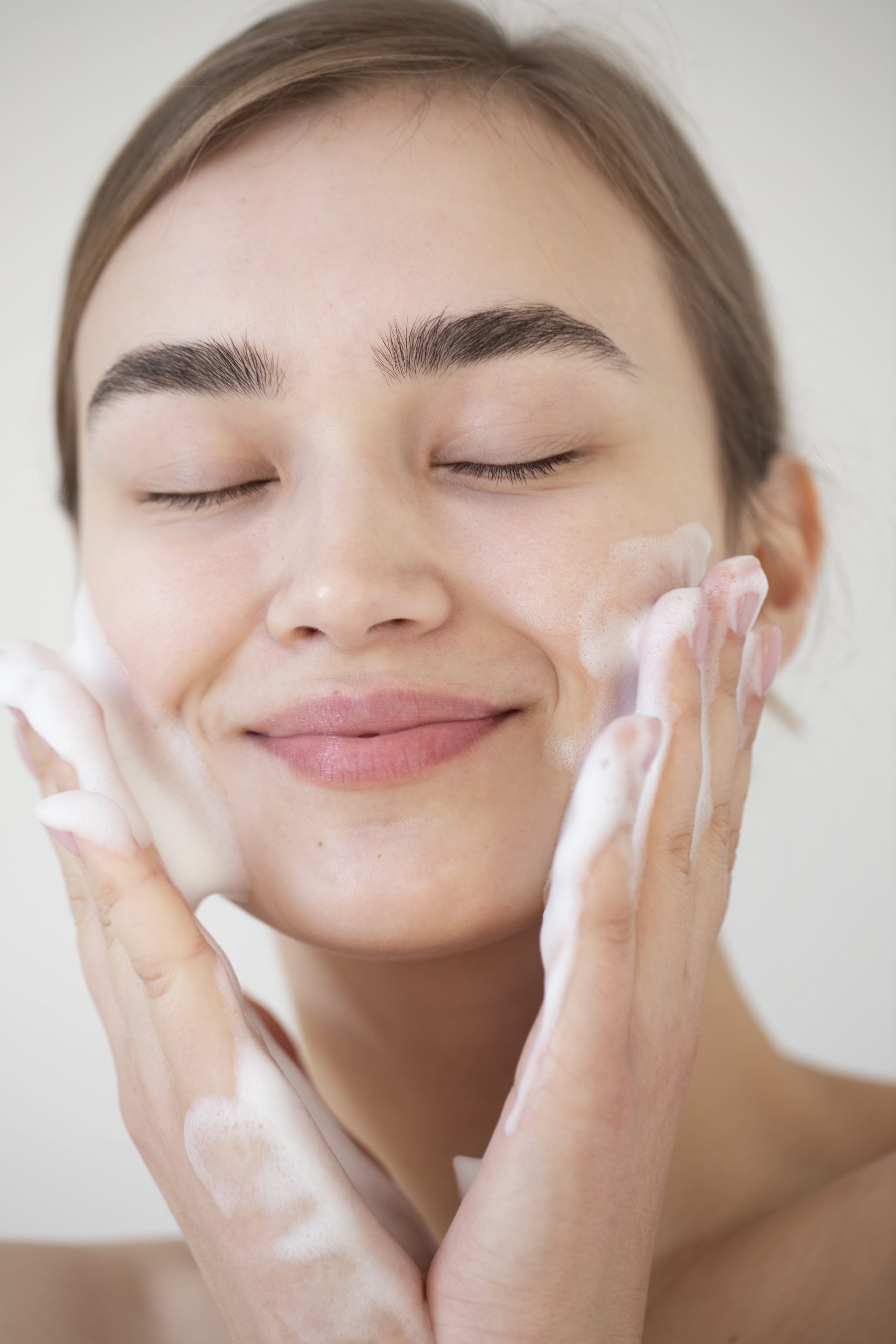 portrait-beautiful-woman-with-clear-skin-washing-face-with-foam-cleanser